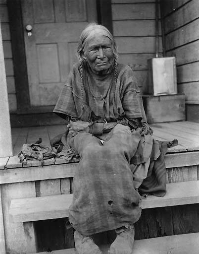 Nez Perce woman named Chica-ma-poo and known as Old Jean sits on porch steps of wooden house, Colville Indian Reservation, Washington, ca. 1903. Edward H. Latham Collection no. 409. University of Washington.